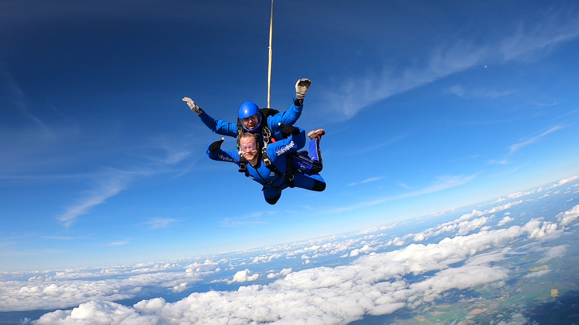 Tandem skydive customer in freefall smiling at camera